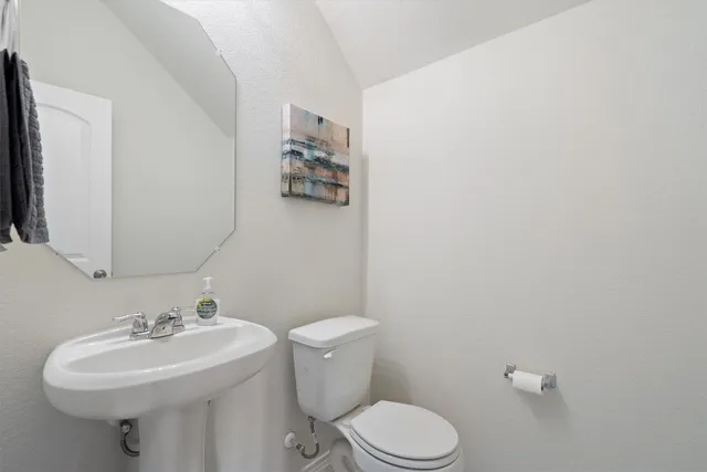 a bathroom with a sink mirror and toilet