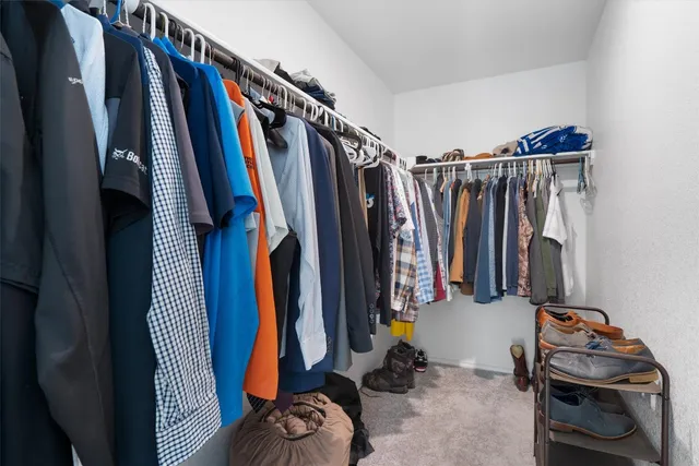 a view of walk in closet with clothes and shoes