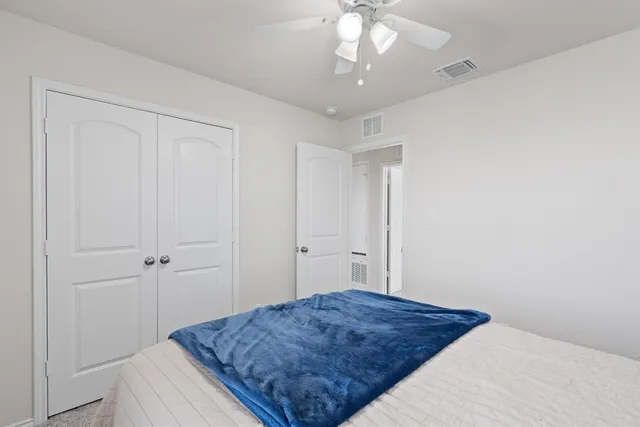 a bedroom with a bed and a chandelier fan