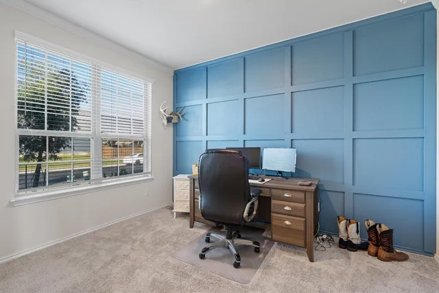 a view of a workspace with furniture and a window