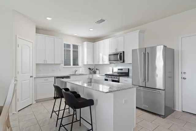 a kitchen with stainless steel appliances a refrigerator stove microwave and cabinets