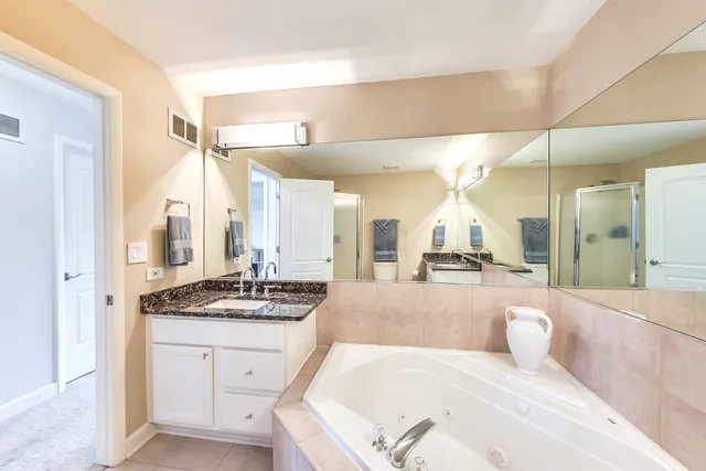a large bathroom with a granite countertop sink mirror and a bath tub