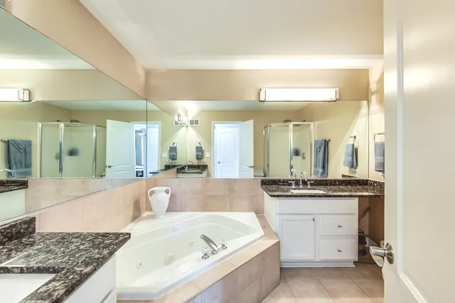a large bathroom with a tub a sink and a large mirror