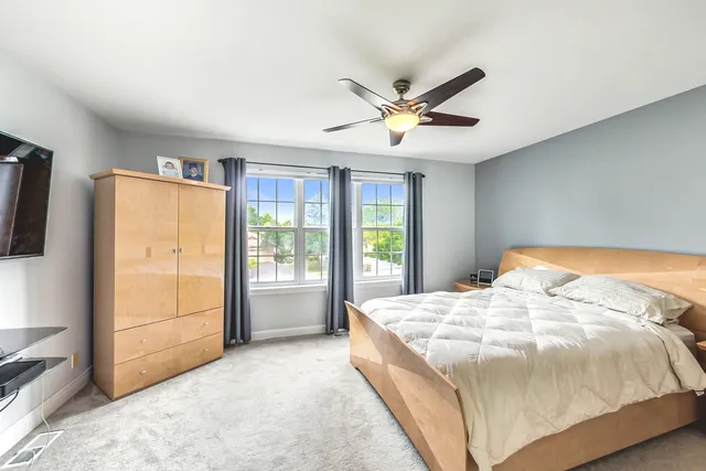 a bed sitting in a spacious bedroom next to a window