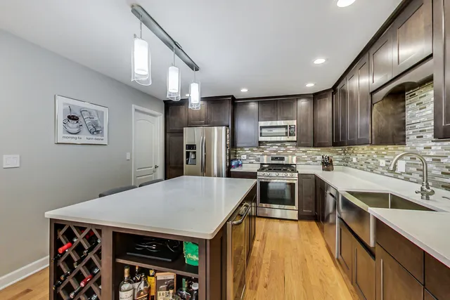 a kitchen with kitchen island a counter space a sink appliances and cabinets