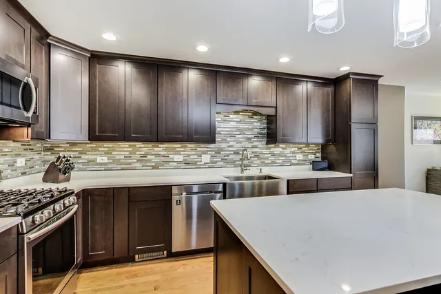 a kitchen with stainless steel appliances granite countertop a sink and a stove