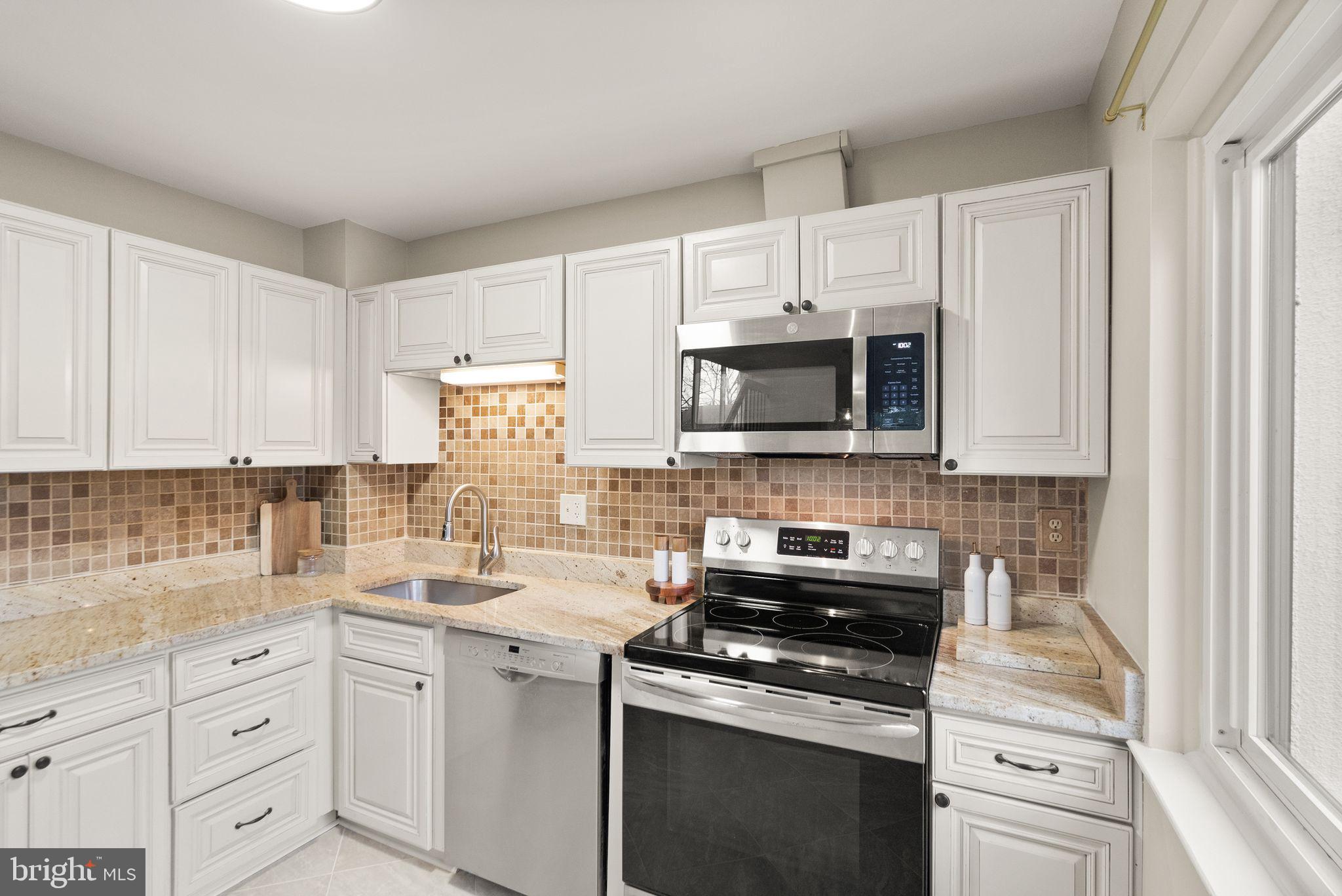 11801 Coopers Court Reston, VA 20191 - Photo 22 of 66 a kitchen with white cabinets and appliances