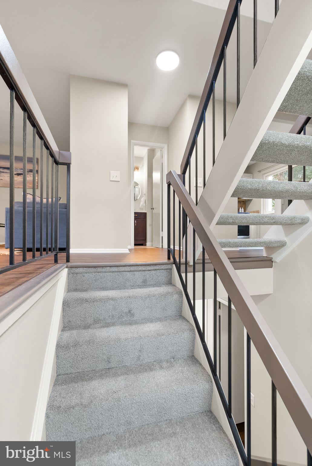 11801 Coopers Court Reston, VA 20191 - Photo 7 of 66 a view of staircase with lots of frames on wall and a clock