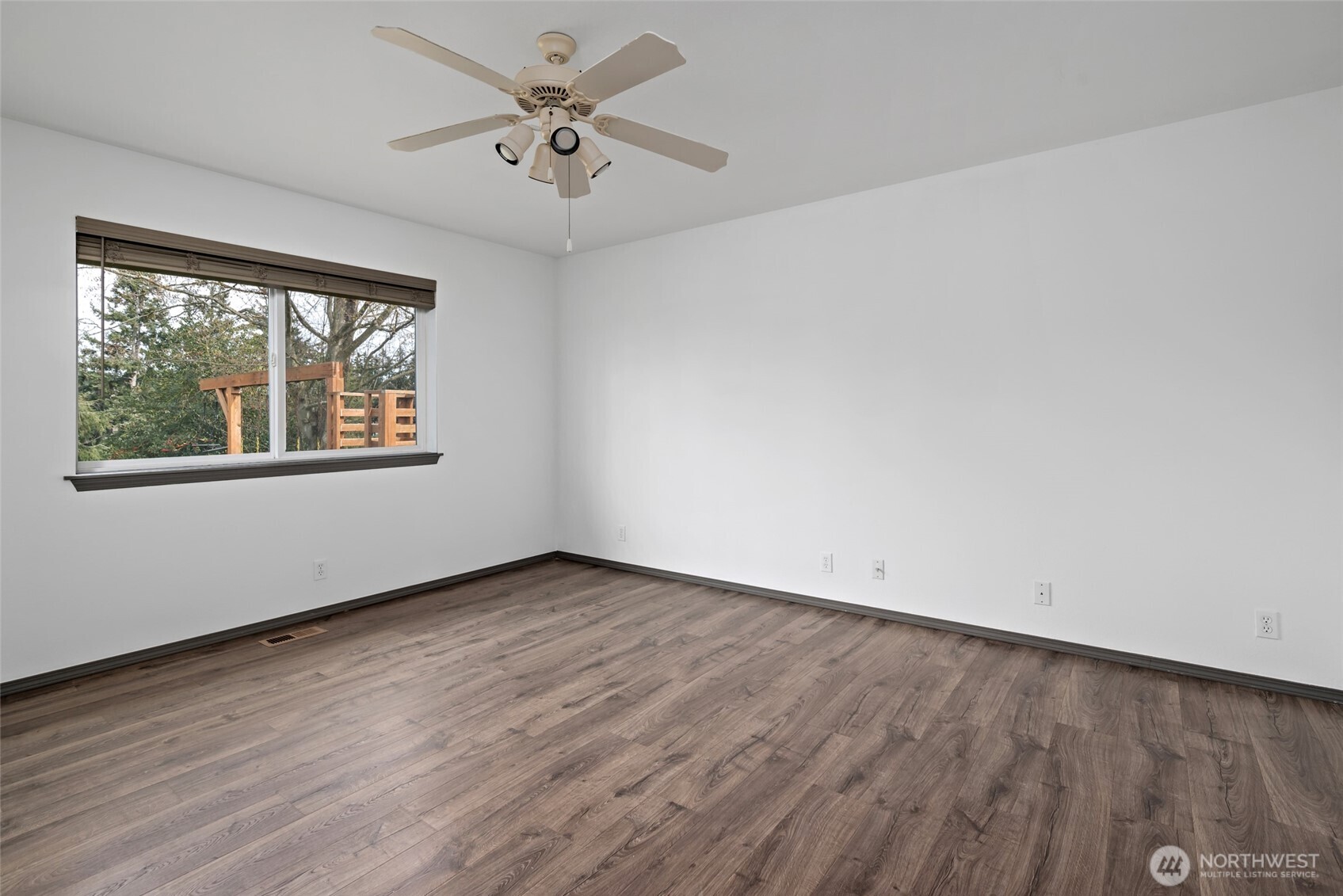 2060 Southwest 16th Avenue Oak Harbor, WA 98277 - Photo 26 of 40 an empty room with wooden floor chandelier fan and windows