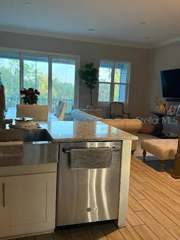 a living room with stainless steel appliances furniture and a large window
