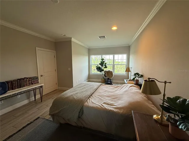 a bedroom with a bed and wooden floor