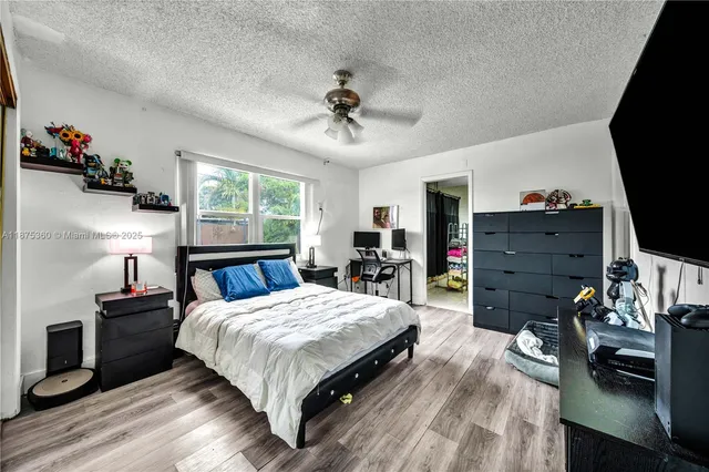 a bedroom with a bed and a flat tv screen on dresser