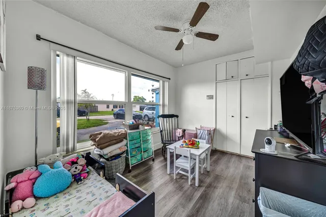 a living room with furniture a flat screen tv and a large window