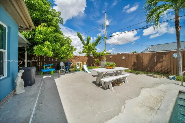 a view of a patio with table and chairs potted plants