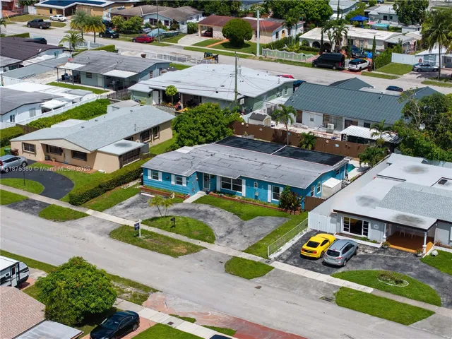 an aerial view of residential houses and car parked