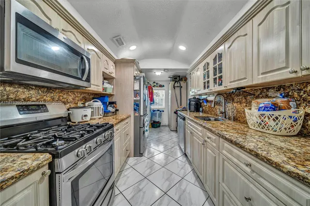 a kitchen with stainless steel appliances granite countertop a stove and a sink