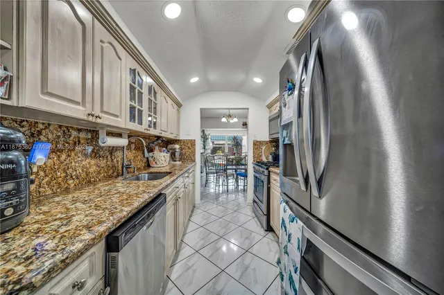 a kitchen with granite countertop a refrigerator and a stove