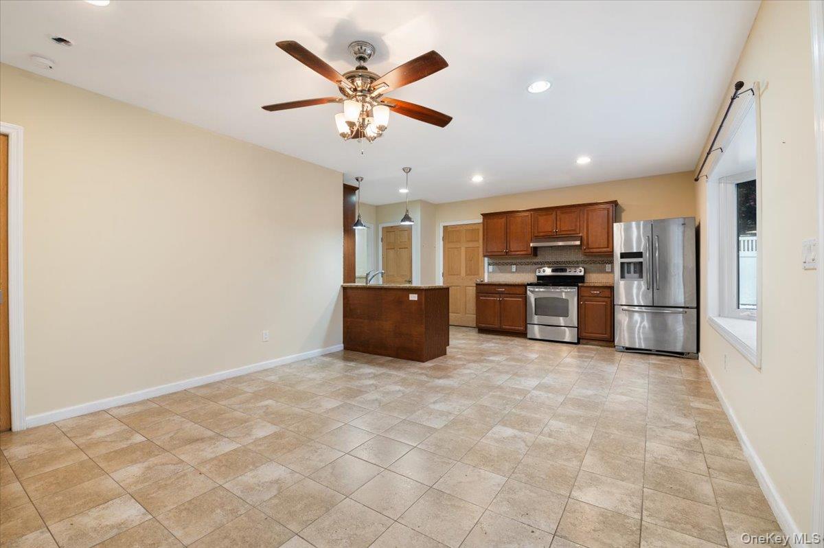 33 Fleets Cove Road Huntington, NY 11743 - Photo 26 of 42 Kitchen with stainless steel appliances, recessed lighting, ceiling fan, brown cabinetry, and tasteful backsplash