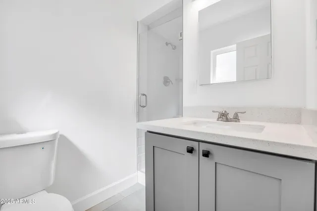 a bathroom with a granite countertop sink a toilet and a mirror