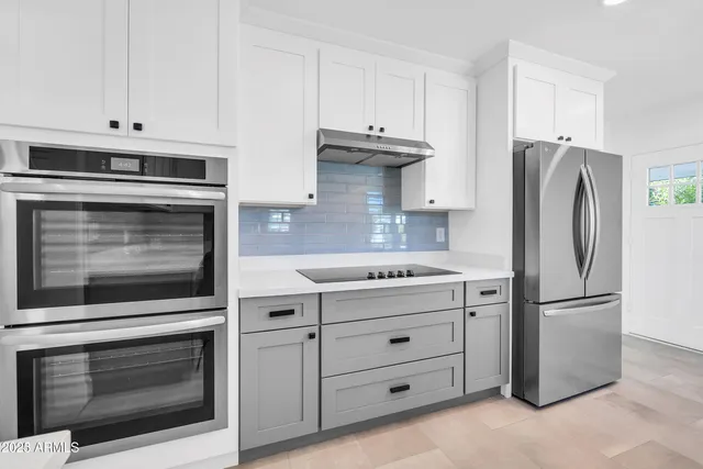 a kitchen with cabinets and stainless steel appliances