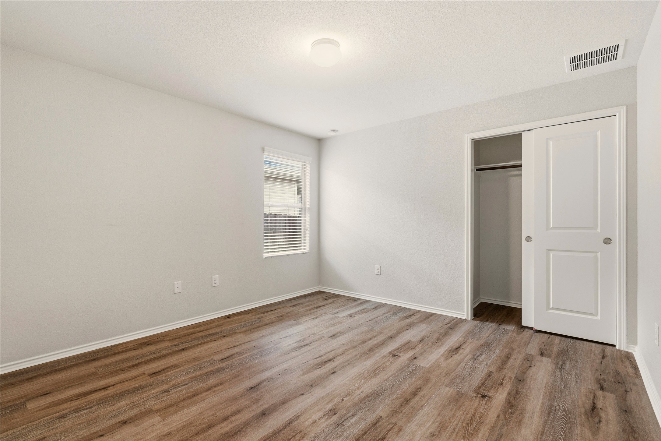 3721 Alpine Autumn Drive Austin, TX 78744 - Photo 23 of 29 a view of an empty room with wooden floor and a window