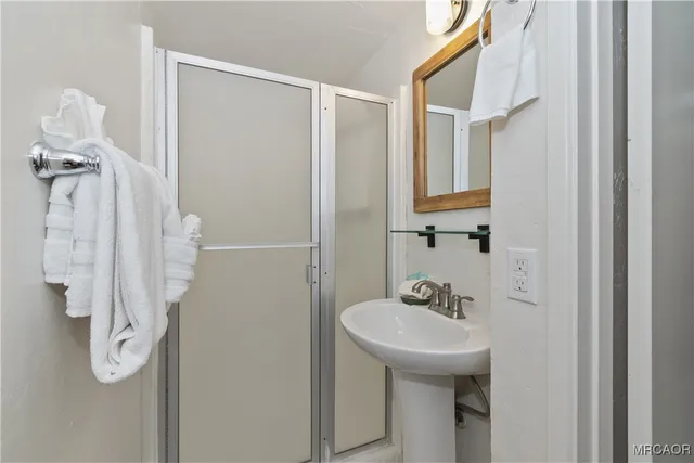 a bathroom with a sink a mirror and shower