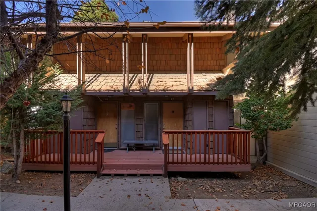 a view of a wooden deck with large trees and wooden fence