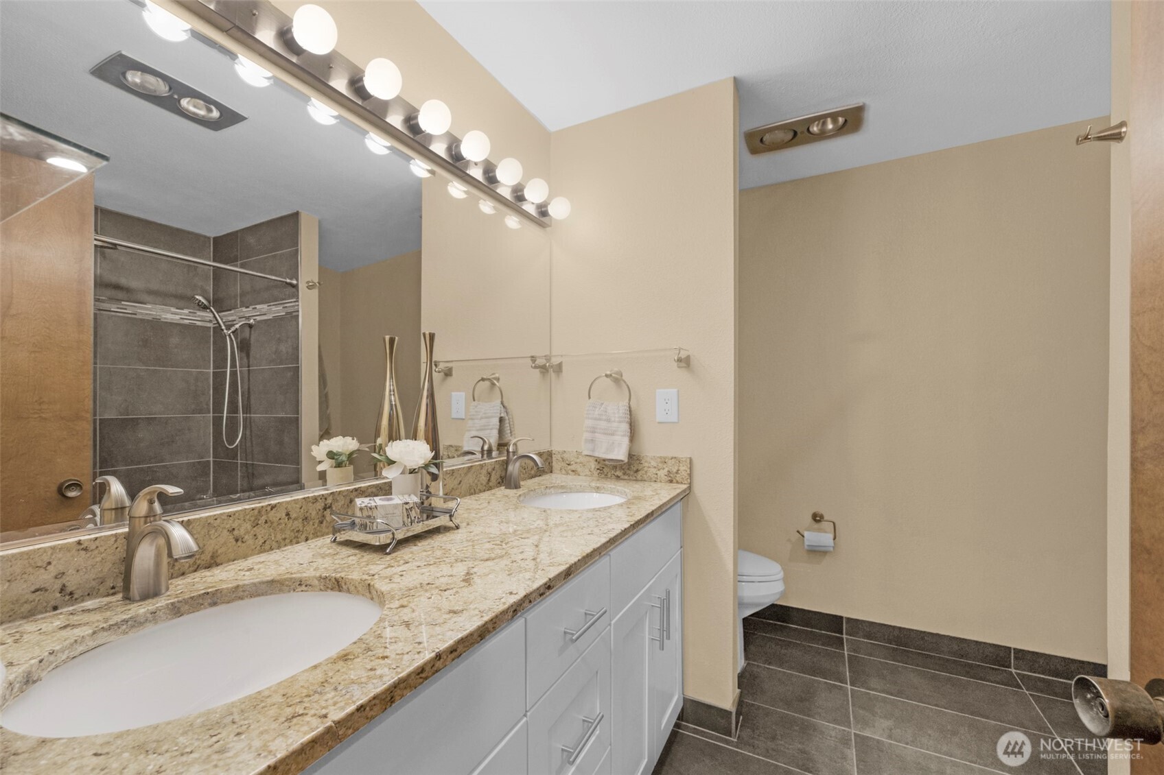 200 James Street, Unit 307 Edmonds, WA 98020 - Photo 17 of 37 a bathroom with a granite countertop sink a mirror and a shower
