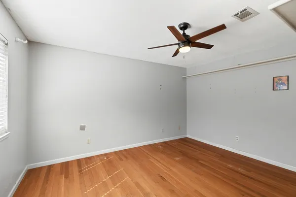 a view of empty room with wooden floor