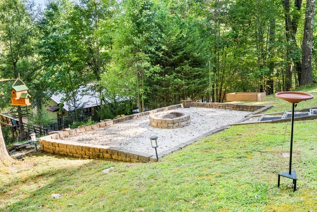 a view of backyard with large trees and wooden fence