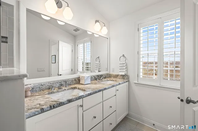 a spacious bedroom with a bed a couch and a large window