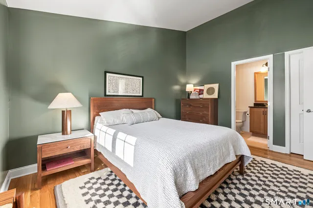a bathroom with a granite countertop sink toilet and mirror