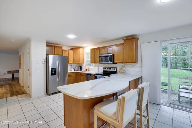 a kitchen with stainless steel appliances a refrigerator a stove a sink dishwasher and white cabinets with wooden floor