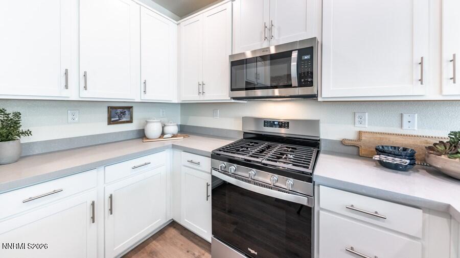 497 Radiant Drive Carson City, NV 89705 - Photo 8 of 23 a kitchen with white cabinets and black appliances