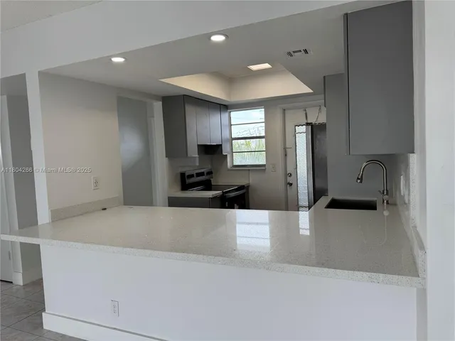 a large white kitchen with a large window