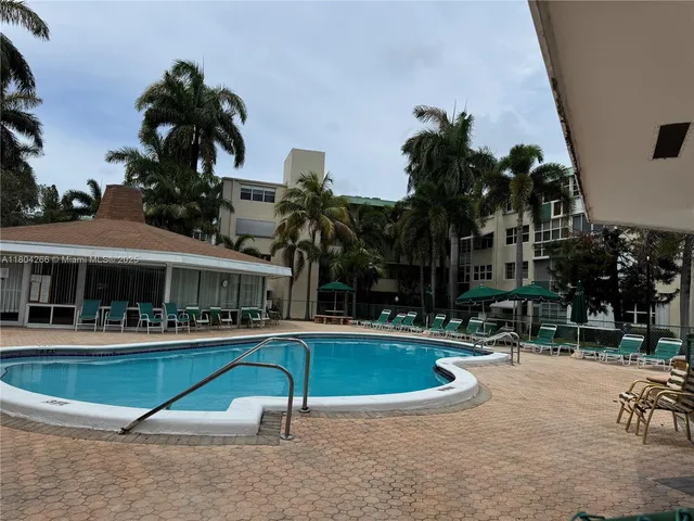 a view of a swimming pool with a bench and tables