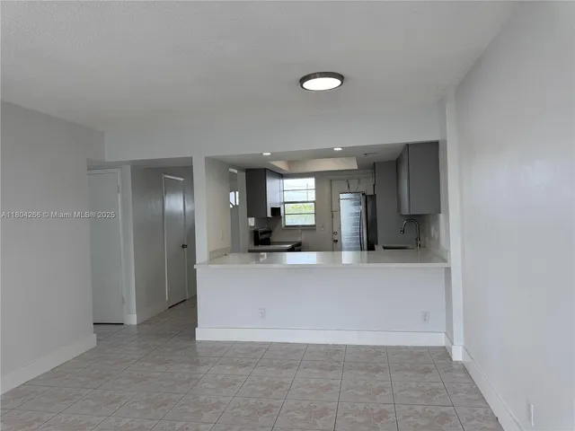 a view of a kitchen with a refrigerator and a sink