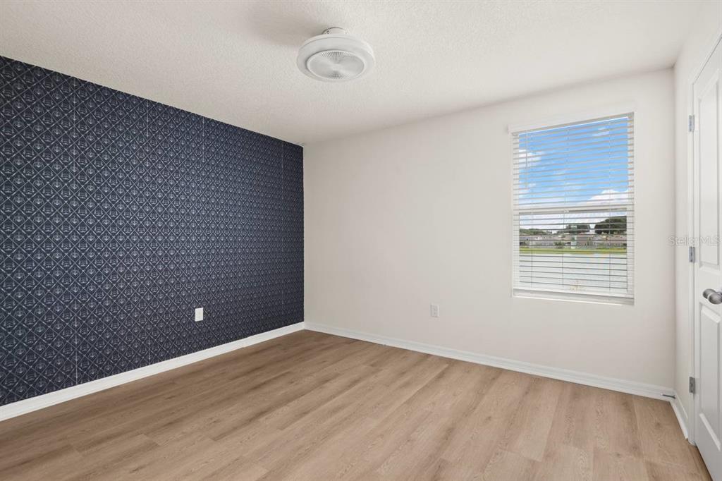 7782 Sail Clover Lane Zephyrhills, FL 33540 - Photo 12 of 22 a view of an empty room with wooden floor and a window