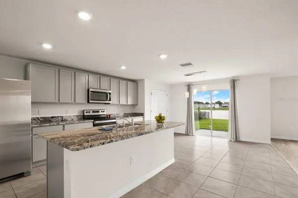 a kitchen with stainless steel appliances granite countertop a stove a sink and a refrigerator