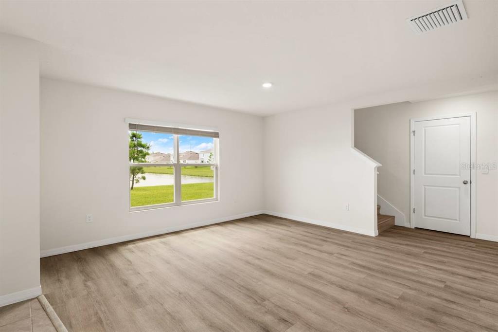 7782 Sail Clover Lane Zephyrhills, FL 33540 - Photo 4 of 22 an empty room with wooden floor and windows