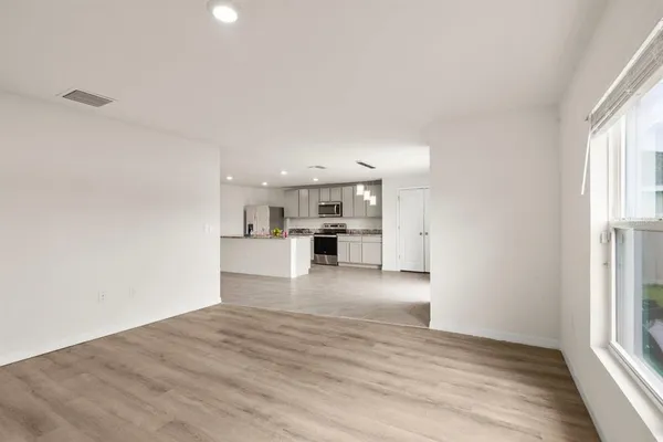 a view of a kitchen with wooden floor and windows