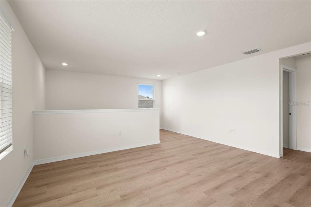 7782 Sail Clover Lane Zephyrhills, FL 33540 - Photo 6 of 22 a view of an empty room with wooden floor and a window