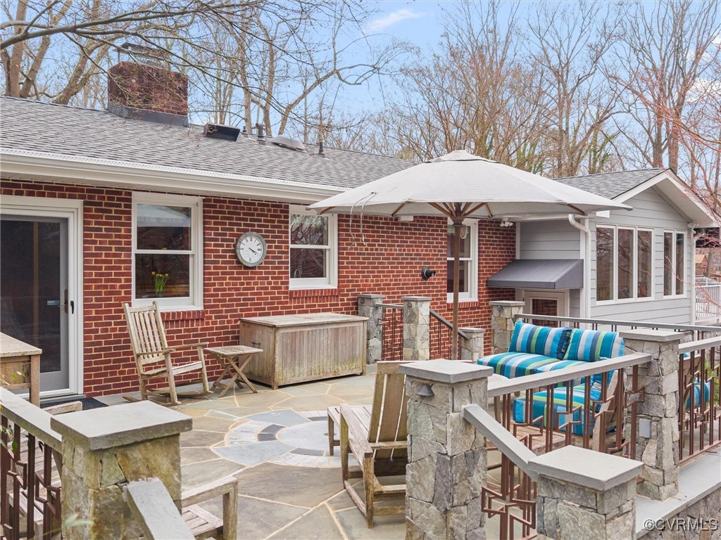 8654 Fieldcrest Road Richmond, VA 23235 - Photo 44 of 48 a roof deck with table and chairs under an umbrella