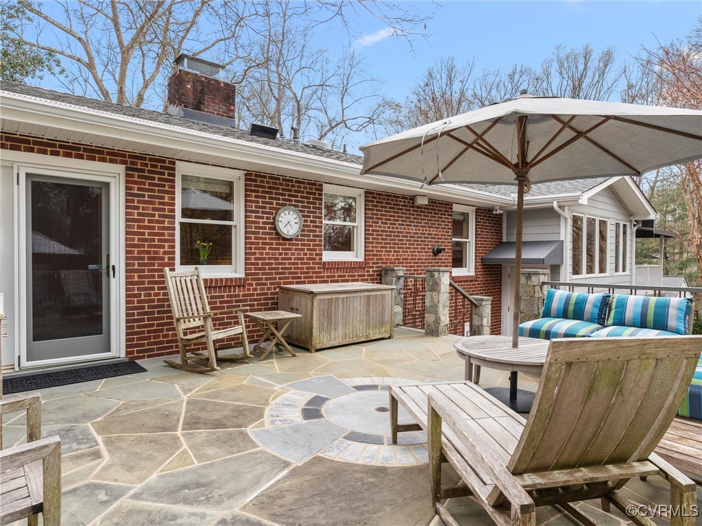 8654 Fieldcrest Road Richmond, VA 23235 - Photo 45 of 48 a view of a patio with table and chairs under an umbrella