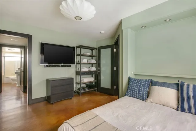 a bedroom with a bed and flat screen tv