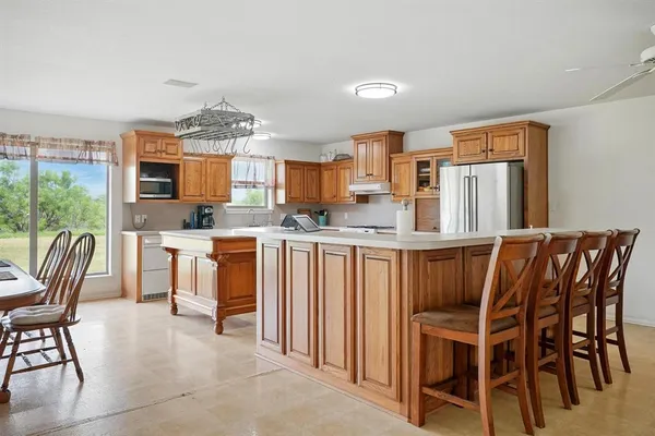 a kitchen with stainless steel appliances kitchen island granite countertop a table and chairs