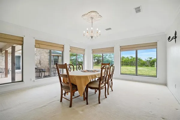 a dining room with furniture a chandelier and wooden floor