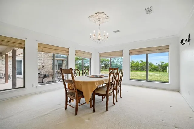 a dining room with furniture a chandelier and wooden floor