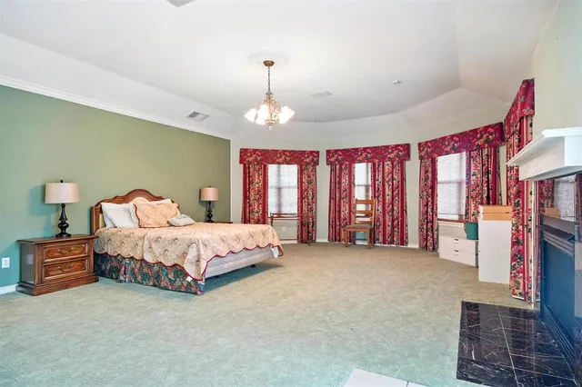 a spacious bedroom with a bed and a chandelier