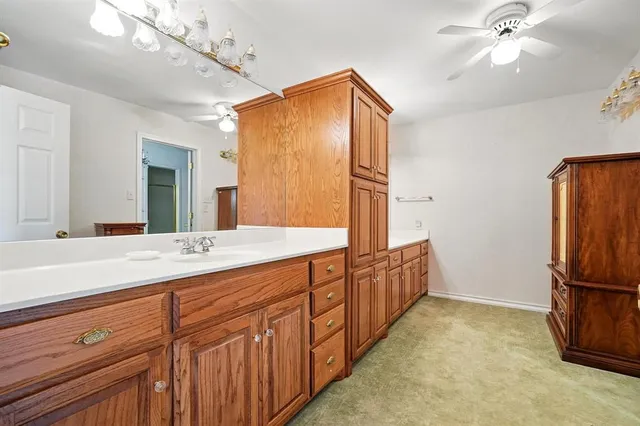 a bathroom with a granite countertop double vanity sink and mirror